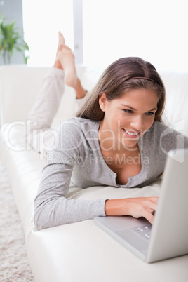 Woman on the sofa writing an e-mail