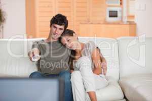 Couple on the sofa watching television together