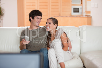 Laughing couple watching funny movie together