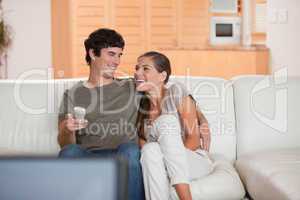Laughing couple watching funny movie together