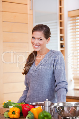 Smiling woman with vegetables in the kitchen