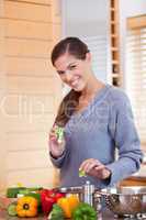 Smiling woman preparing vegetable stew in the kitchen