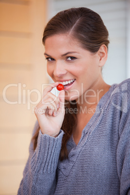 Woman snacking a small tomato