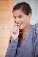 Woman snacking a small tomato