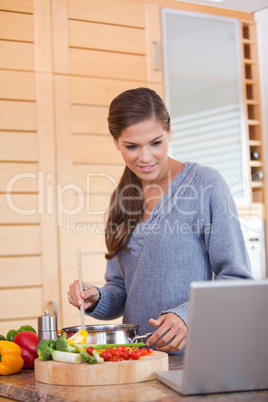 Woman reading off a recipe while cooking
