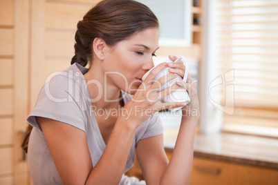 Side view of woman enjoying a cup of coffee