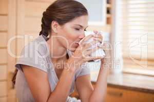 Side view of woman enjoying a cup of coffee