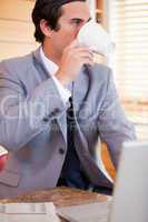 Businessman enjoying a cup of coffee in the kitchen