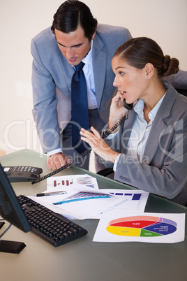 Businesswoman getting a phone call while analyzing statistics