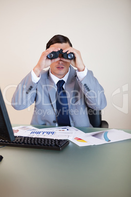 Businessman looking through binoculars