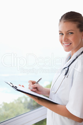 Side view of smiling doctor with clipboard