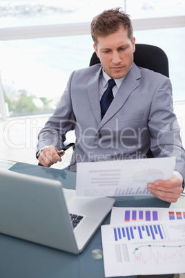 Businessman with market research results leaning back