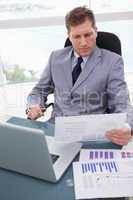 Businessman with market research results leaning back