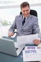 Smiling businessman looking at market research results