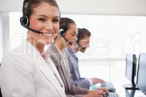 Smiling call center agent colleagues behind her