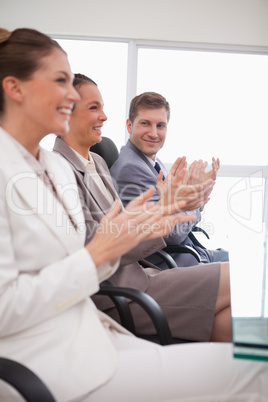 Side view of business team applauding