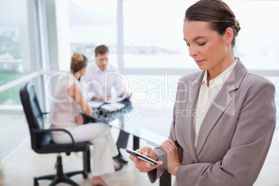 Standing real estate agent with cellphone