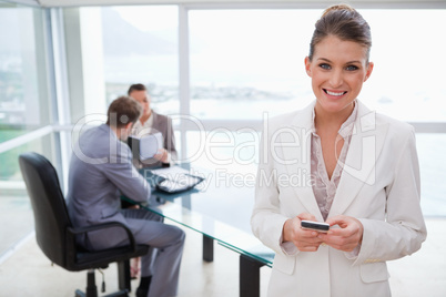 Smiling marketing manager holding cellphone