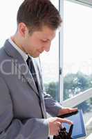 Businessman with tablet in front of the window