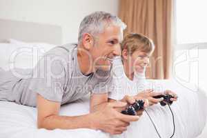 Smiling father and his son playing video games