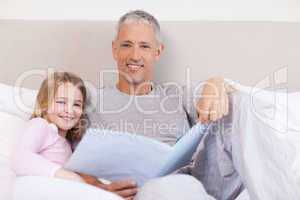 Smiling father reading a story to his daughter