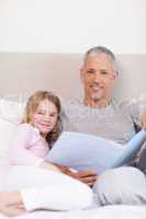 Portrait of a father reading a story to his daughter