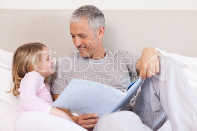 Happy father reading a story to his daughter