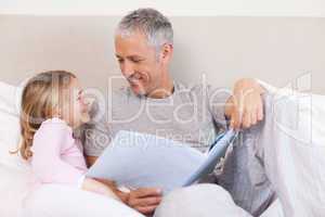 Happy father reading a story to his daughter