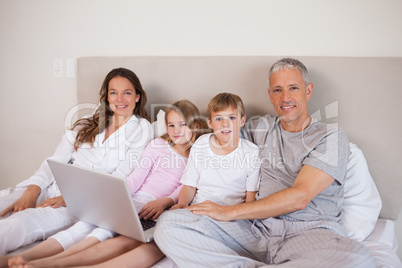 Smiling family using a laptop