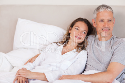 Happy couple lying on a bed