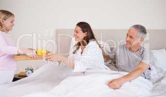 Girl serving breakfast to her parents