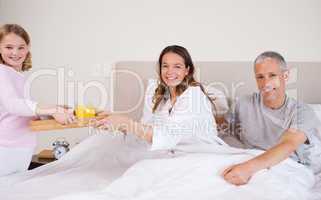 Young girl serving breakfast to her parents