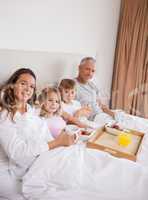 Portrait of a family having breakfast in a bedroom
