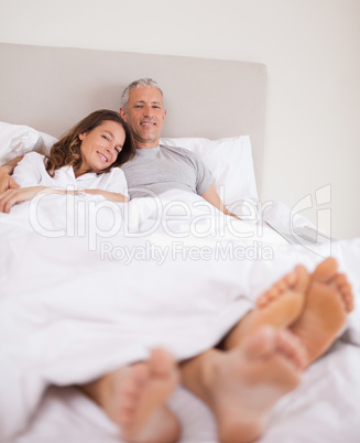Portrait of a lovely couple lying on their bed