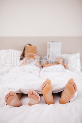 Portrait of woman reading a book while her companion is reading