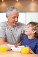 Portrait of a young boy and his father having breakfast