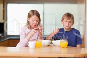 Siblings eating strawberries for breakfast