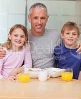 Portrait of a father posing with his children in the morning