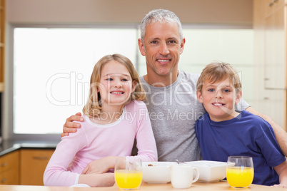 Smiling father posing with his children in the morning
