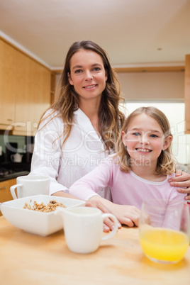 Portrait of a mother and her daughter having breakfast