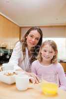 Portrait of a happy mother and her daughter having breakfast