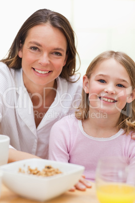 Portrait of a lovely mother and her daughter having breakfast