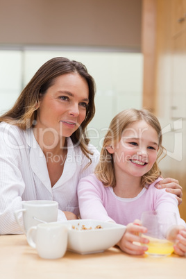 Portrait of a beautiful mother and her daughter having breakfast