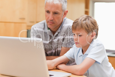 Boy and his father using a laptop