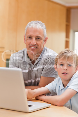 Portrait of a boy and his father using a laptop