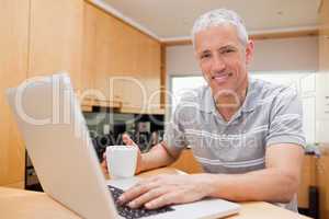 Man using a notebook while drinking tea