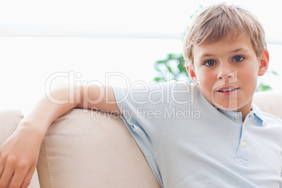 Boy leaning on a sofa