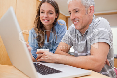 Couple using a laptop while having coffee