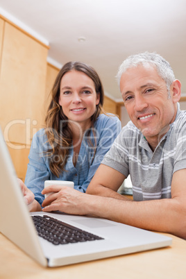 Portrait of a couple using a laptop while having tea