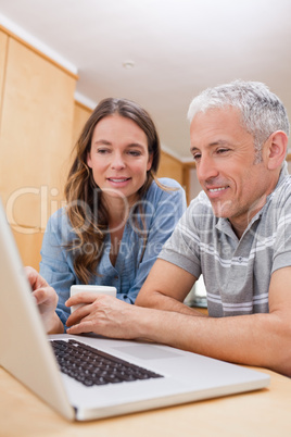 Portrait of a couple using a laptop while having coffee